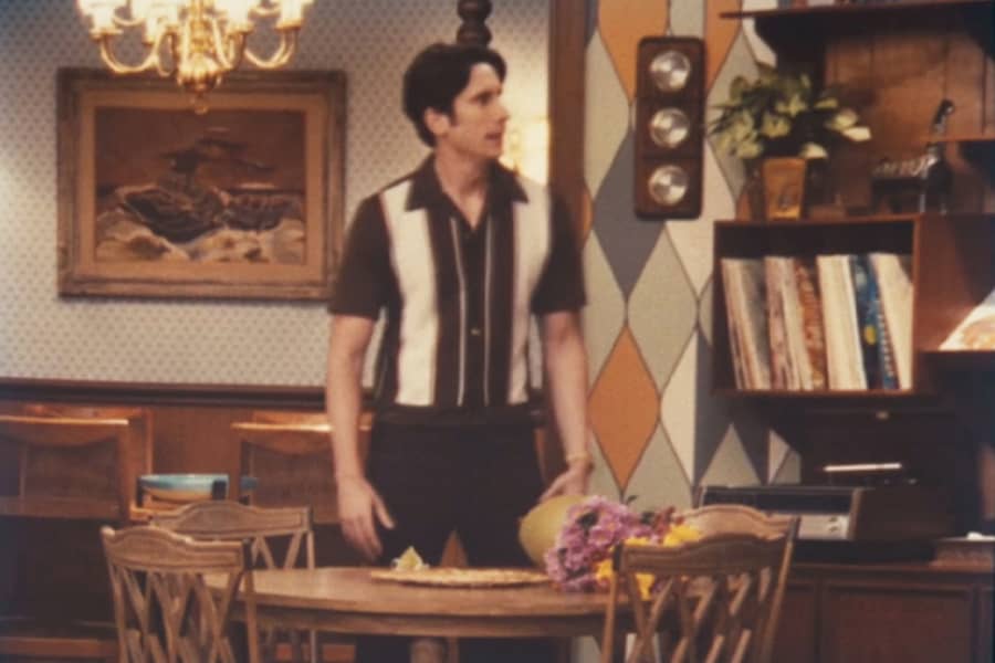 Frank standing by the table with a vase of flowers tipped over