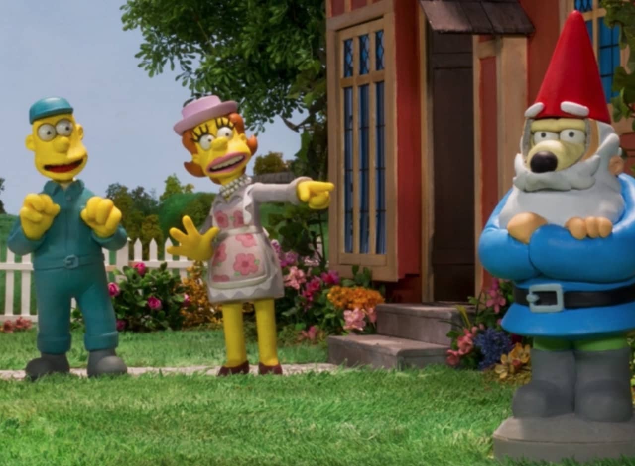claymation-style characters, a man (Willis), a woman, and a dog (Crumble) dressed up as a garden gnome