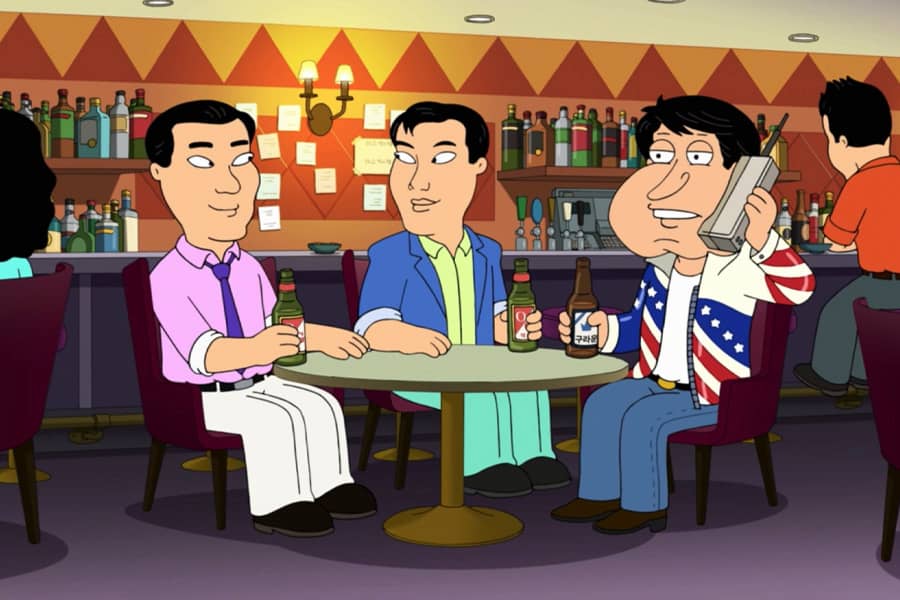 Quagmire as American Johnny, wearing an American flag jacket and sitting in a bar with Japanese coworkers