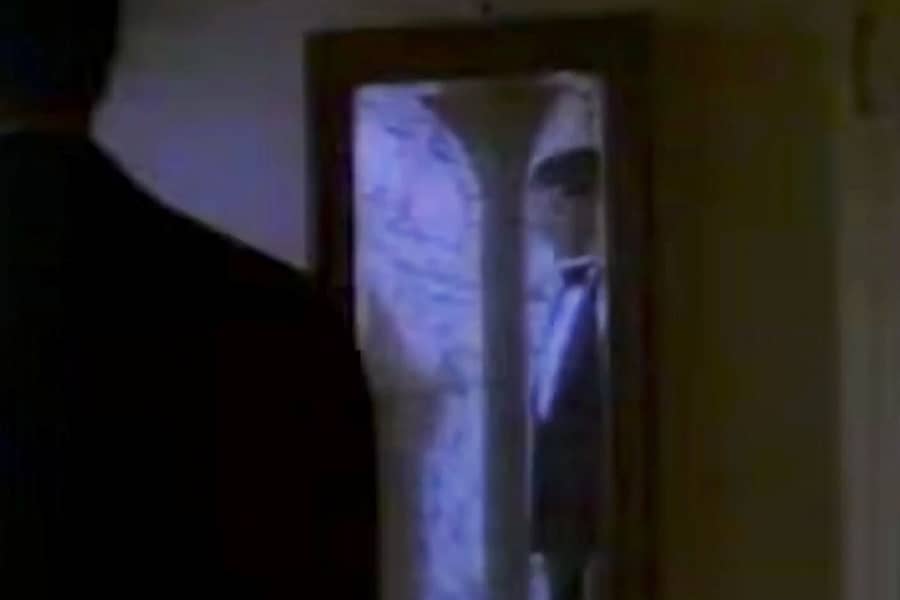 man in a tuxedo reflected in a hallway mirror