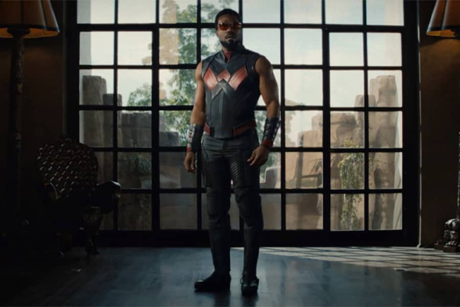 Wonder Man stands in front a window
