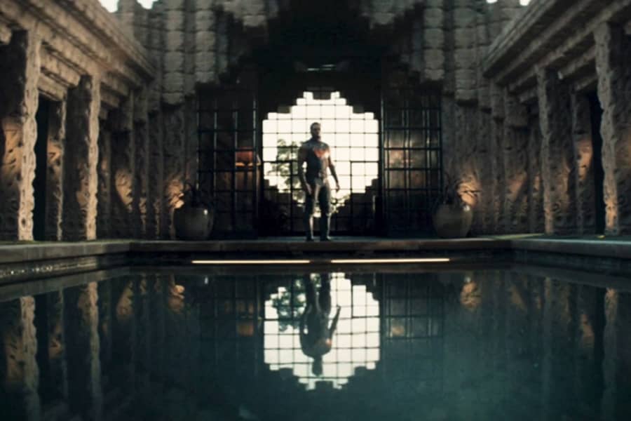 wide shot of a pool and Wonder Man stands at the far end