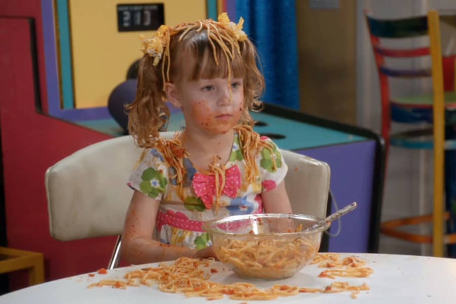 young girl covered in spaghetti