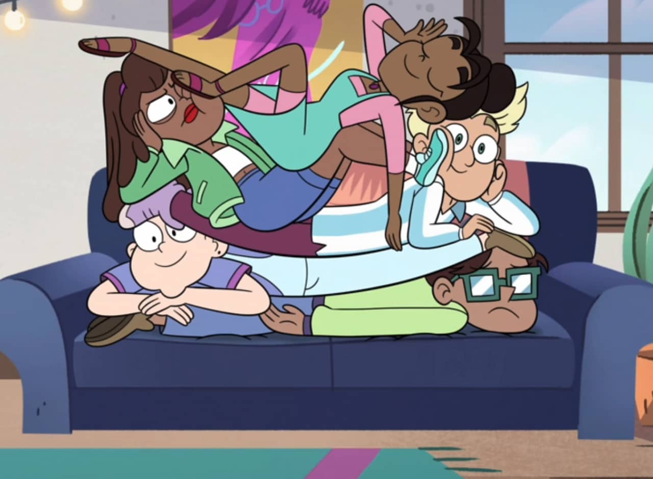 a group of friends piled on top of each other on a couch