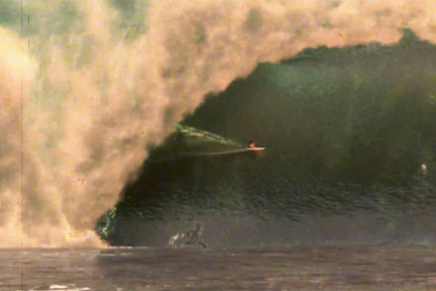 surfer emerging from a ginormous wave