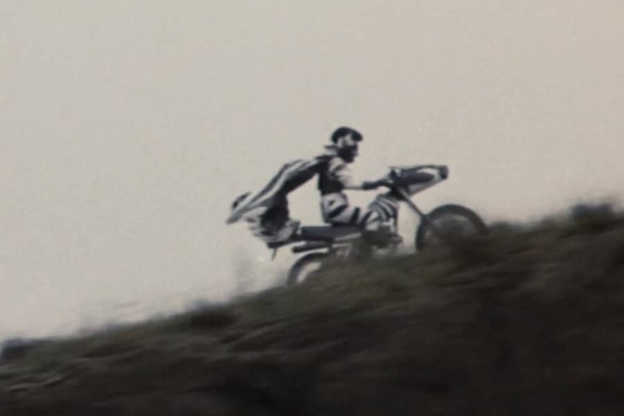 Zebraman rides a motorcycle up a hill