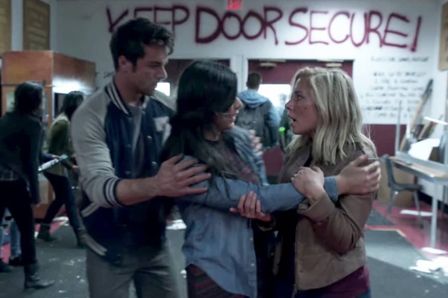 two teens console the girl who narrowly escaped the zombies