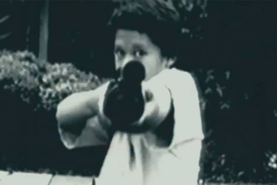 a young boy pointing a gun