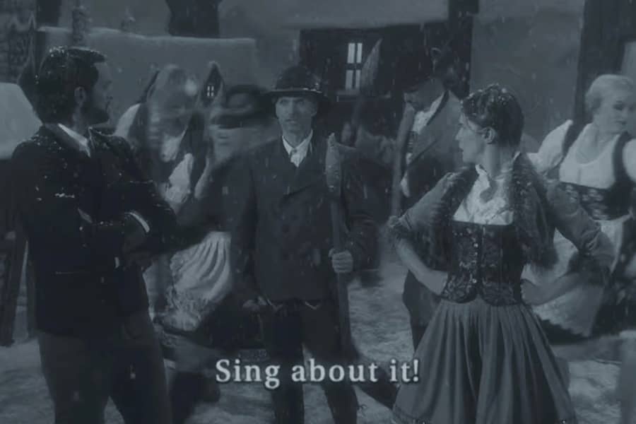 townspeople have gathered and a man says “Sing about it!”